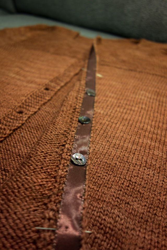 Cria has a brown ribbon with brown shell buttons as backing buttons
